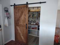 The complete pantry, the barn door was installed and you can see how much our customer is able to fit with all the new shelving.